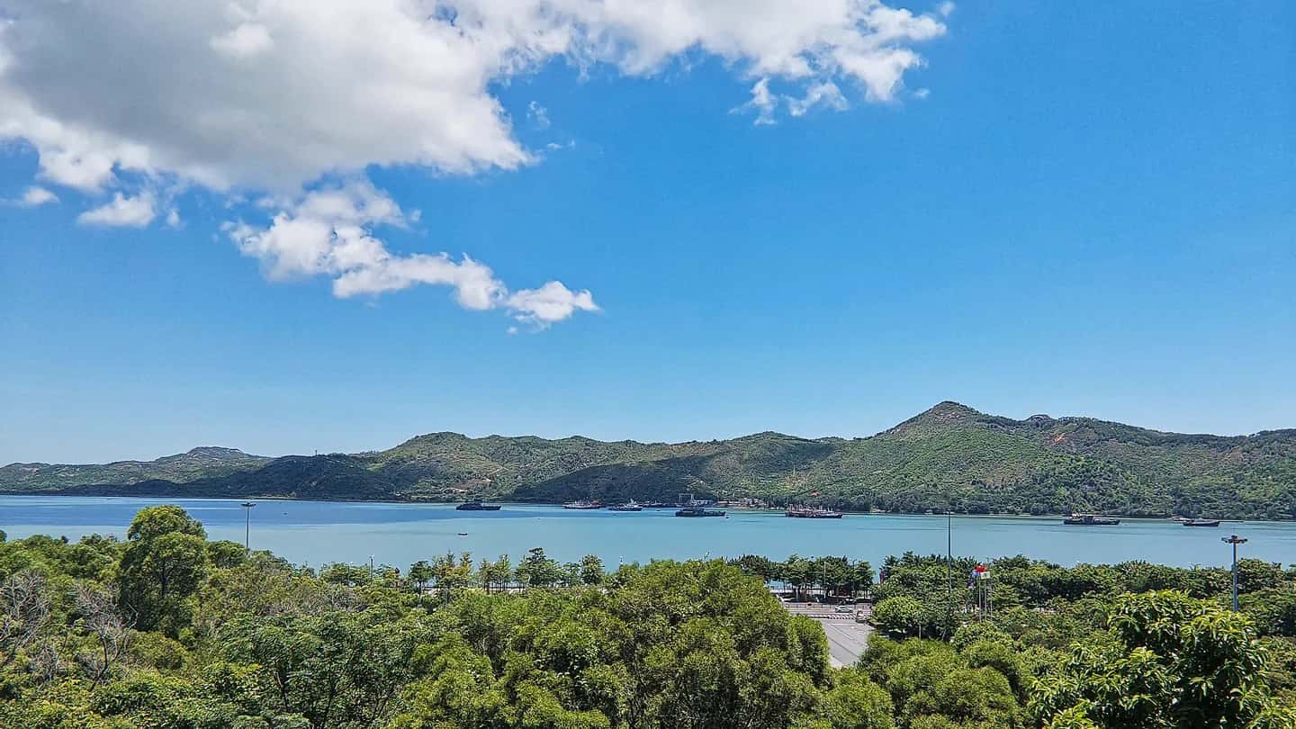 Shanwei Bay and its forested islands under a bright blue sky