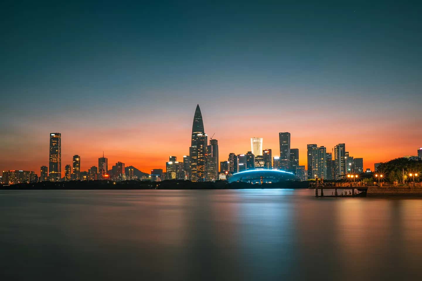 Shenzhen Bay skyline glowing at dusk across the water