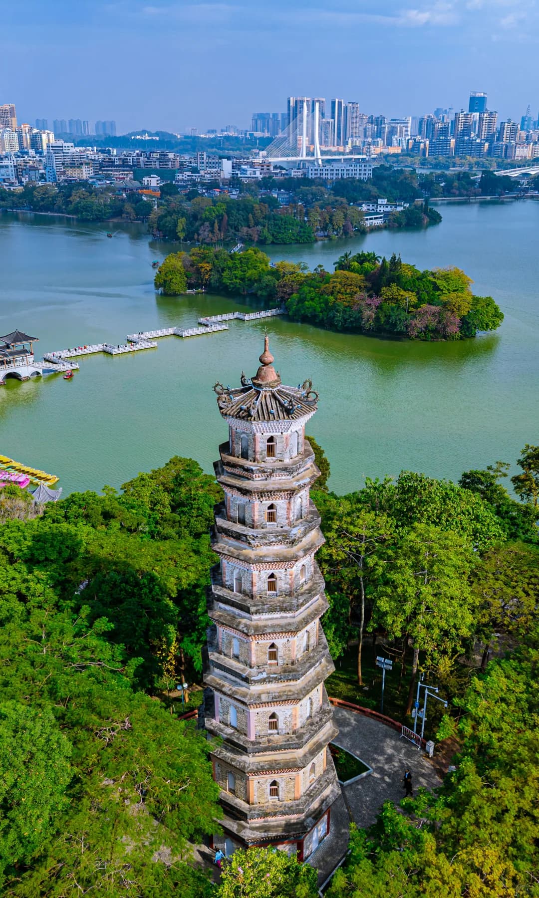 A full-height pagoda above wooded islands and water at Huizhou West Lake
