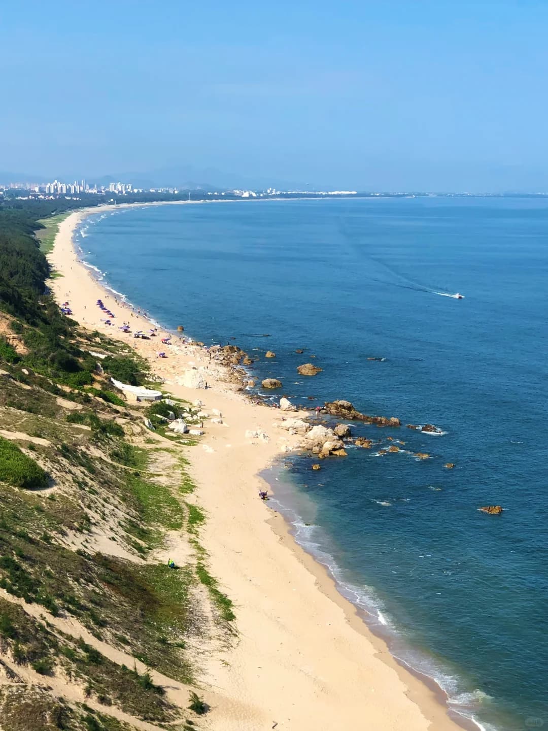 A curving sandy beach and blue sea viewed from Yanjing Ridge in Maoming