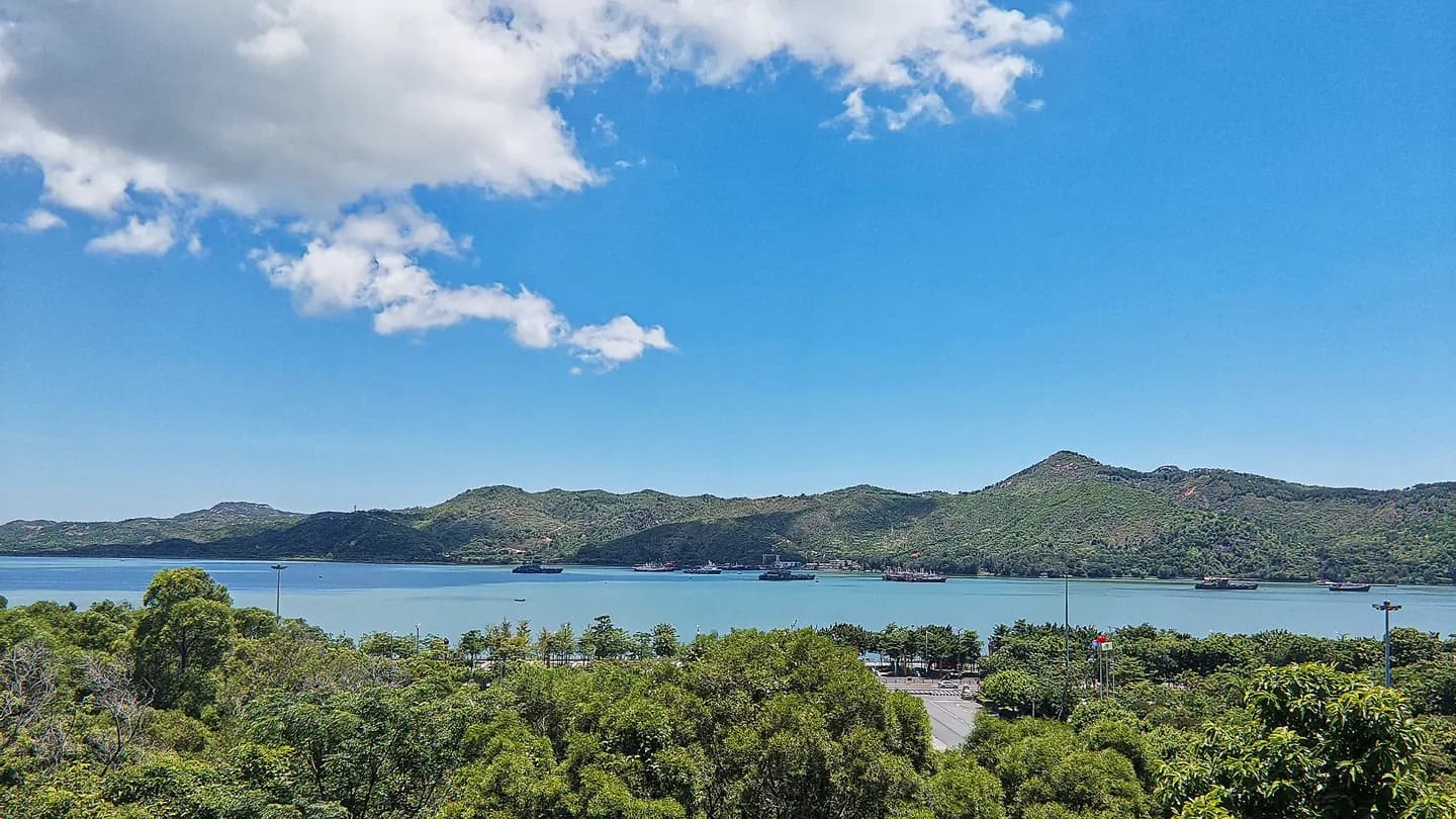 Shanwei Bay and its forested islands under a bright blue sky