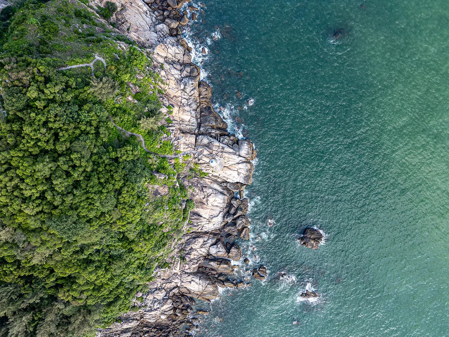 Aerial view of a green headland and clear water on Hailing Island