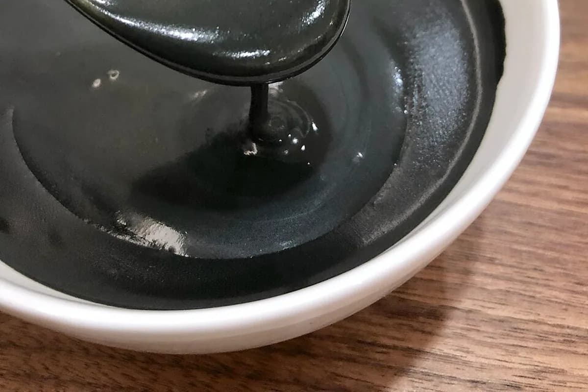Black sesame dessert served in a small ceramic bowl