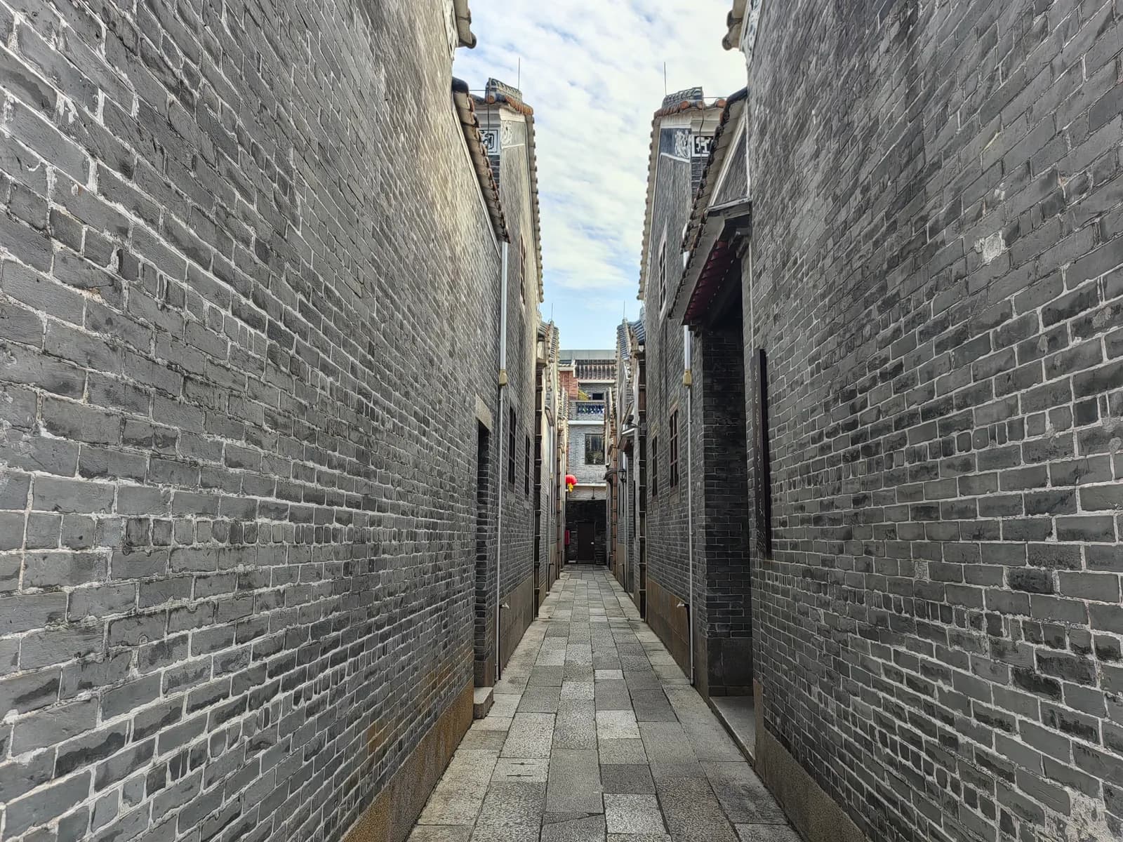 Grey brick alley near garden fabric