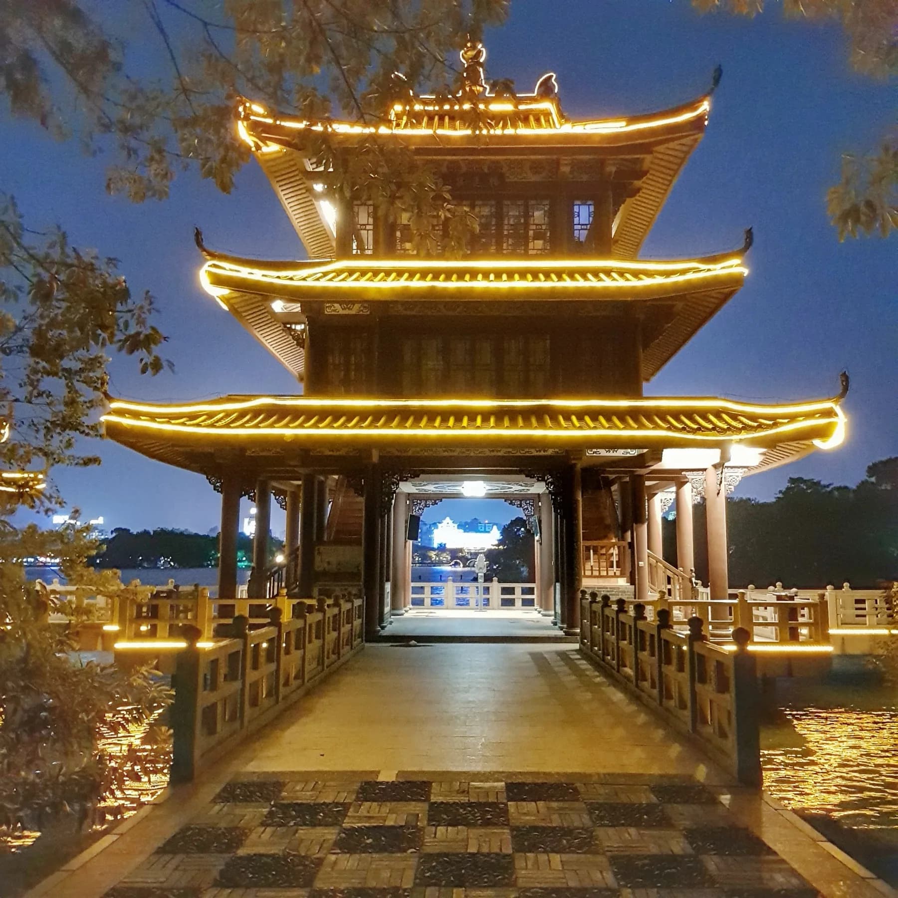 A lit pavilion and bridge beside Huizhou West Lake at night