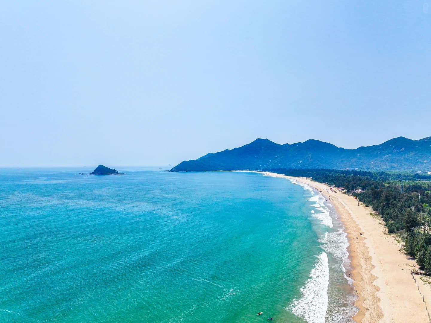 Xichong's broad sandy beach and green headland