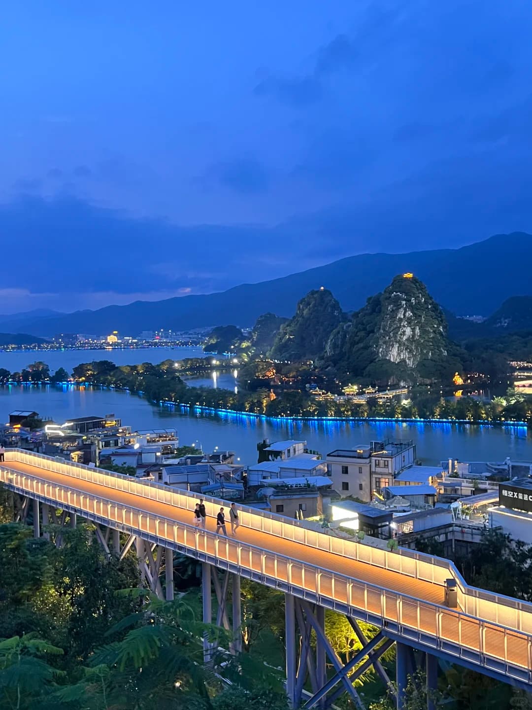 Raised Yanqian Trail above the village, lake and limestone peaks at blue hour
