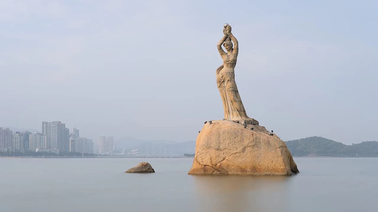 Zhuhai Fisher Girl standing on rocks in Xianglu Bay