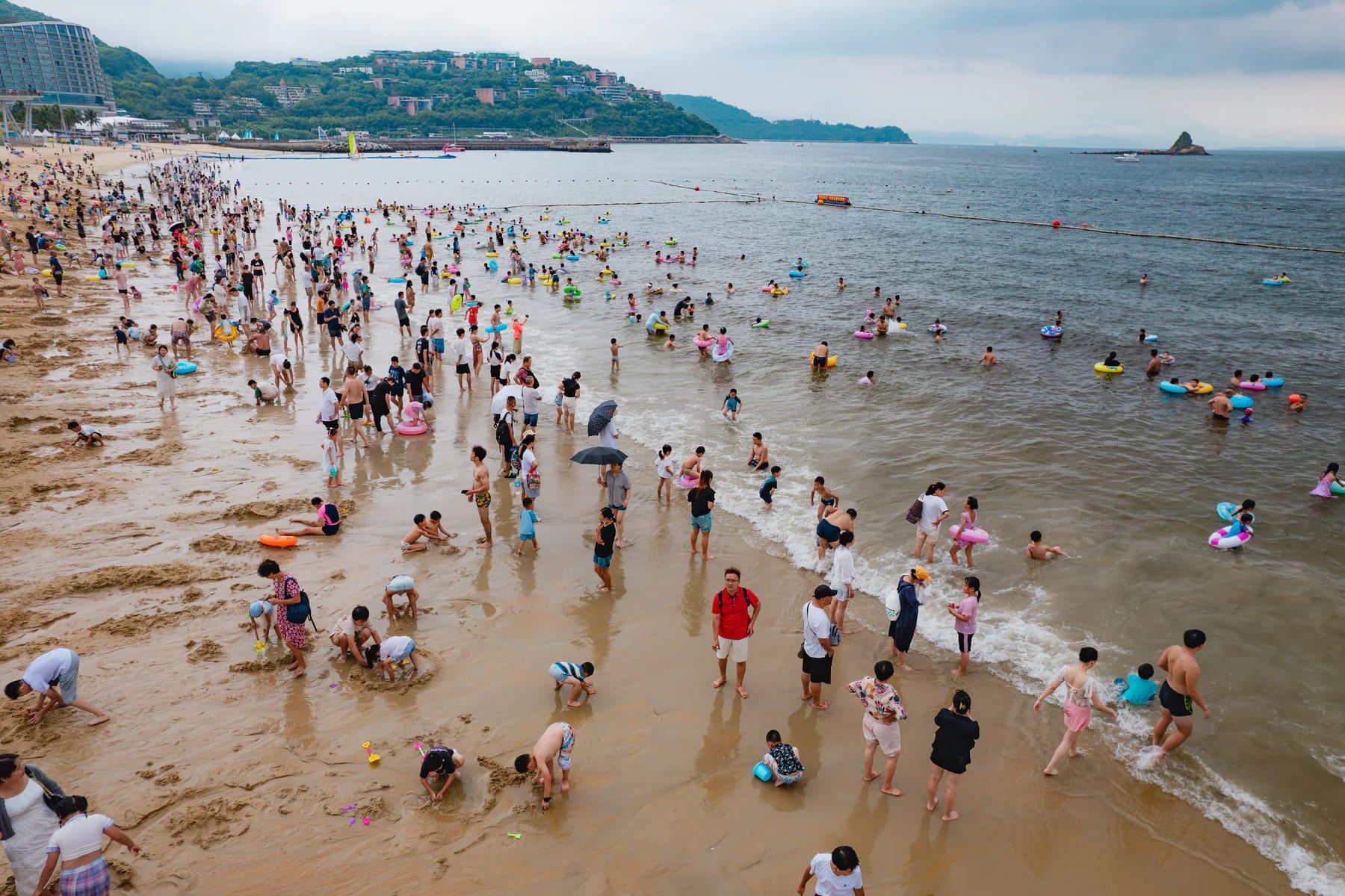 Sandy shore and swimmers at Dameisha Beach Park