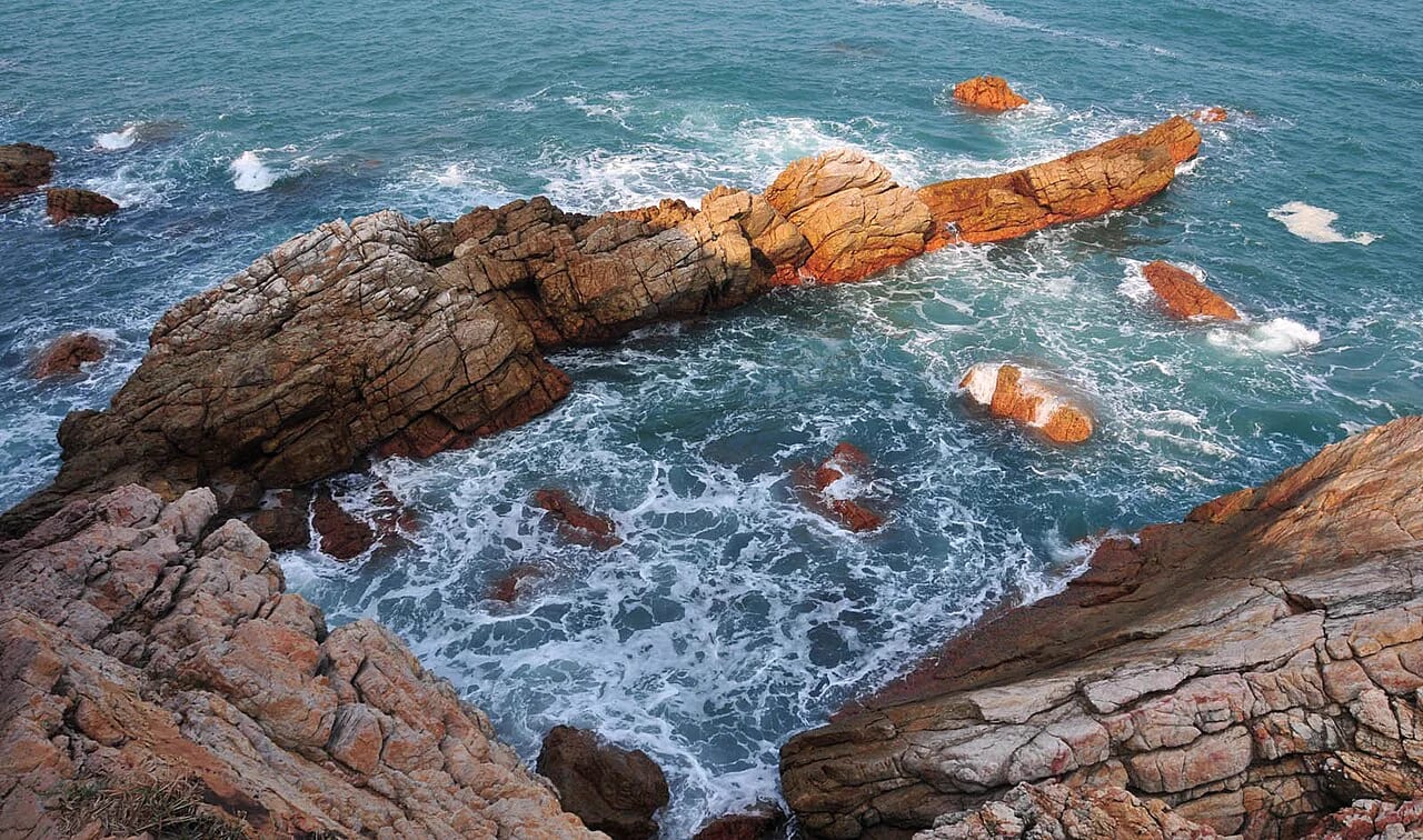 海浪拍打楊梅坑鏽紅色海岸礁石