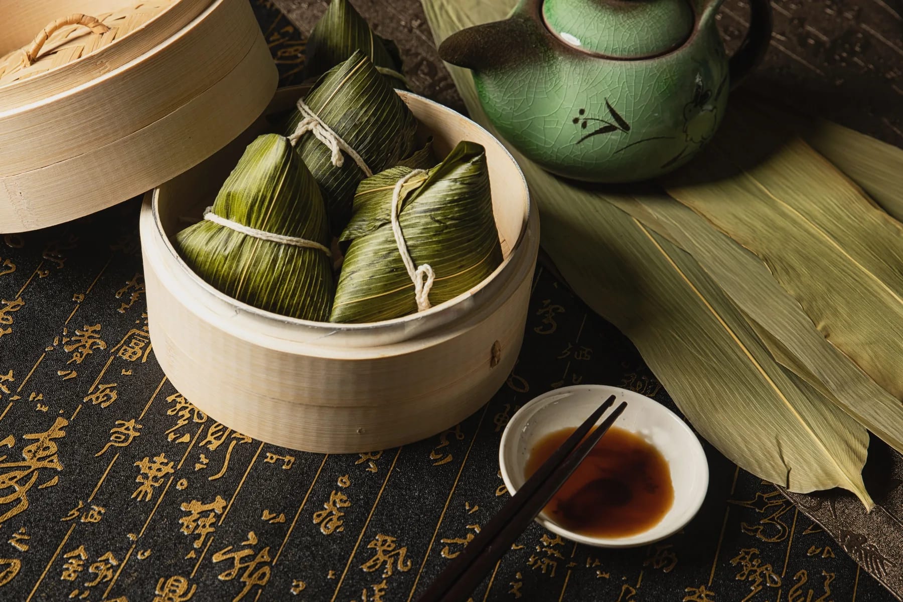 A real photograph of leaf-wrapped rice dumplings in a bamboo steamer