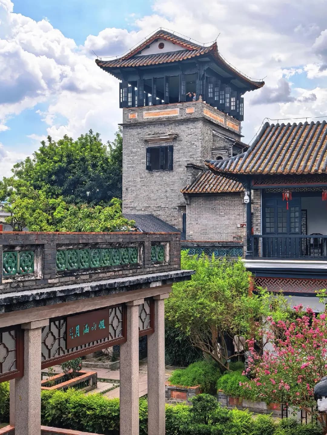 A complete pavilion tower above tiled roofs and garden walkways at Keyuan, Dongguan