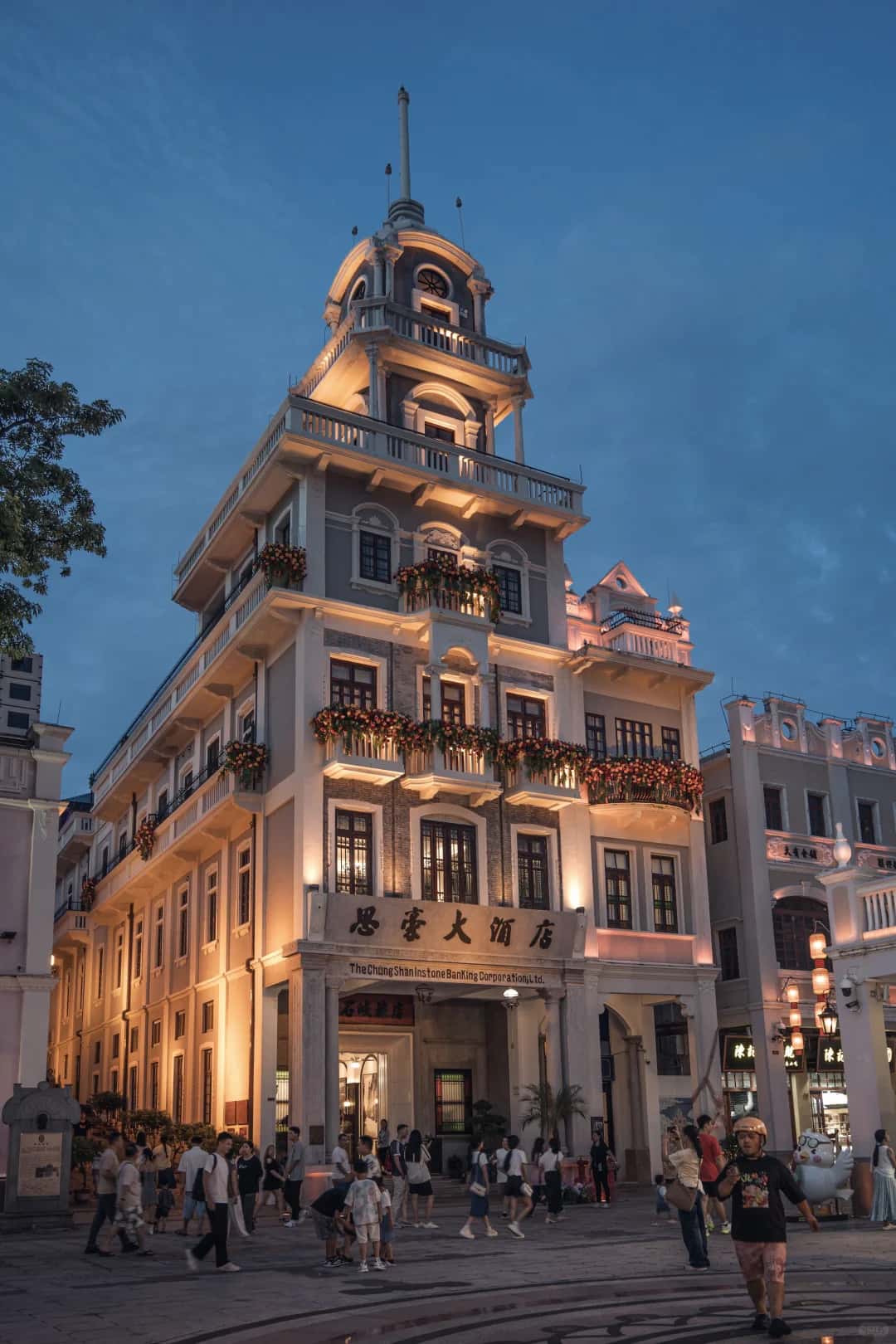 A historic corner building and arcaded street at blue hour on Sunwen West Road, Zhongshan