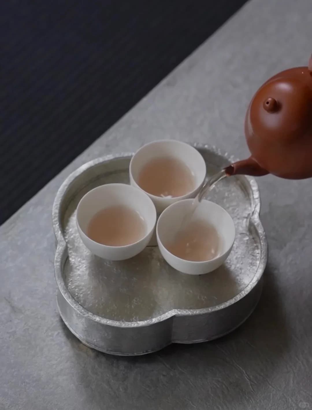 用小泥壺向三隻小瓷杯分茶的潮州工夫茶